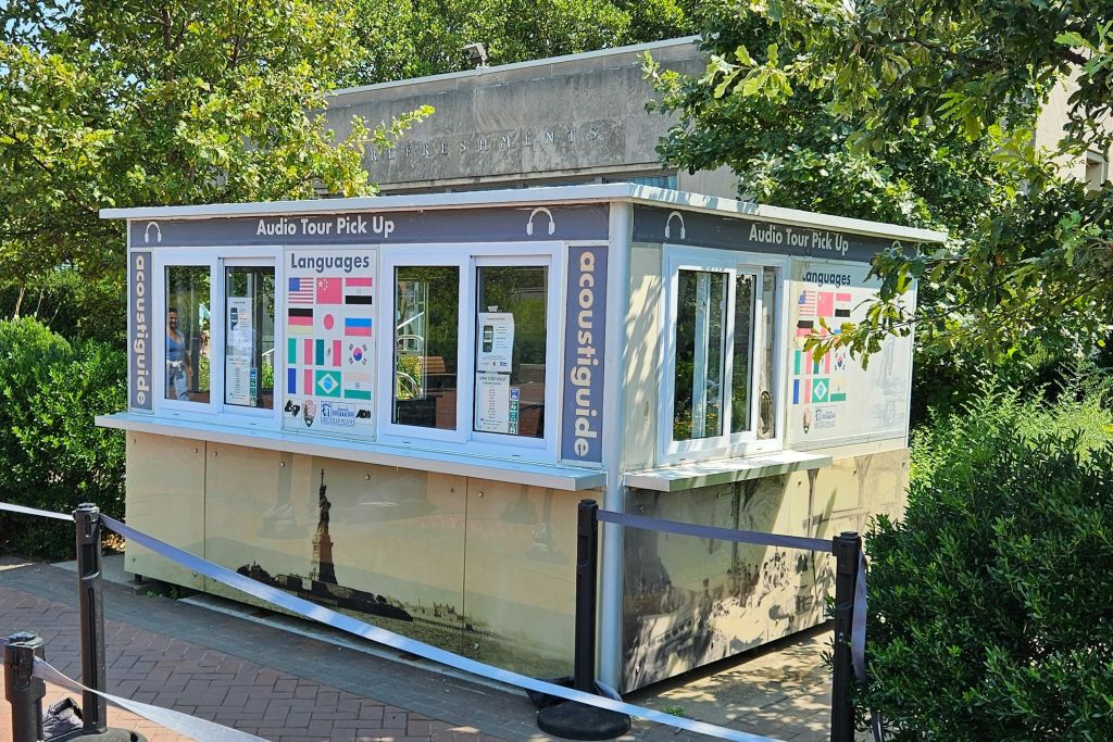 다국어 오디오 투어를 위한 장비를 제공하는 리버티 섬의 부스