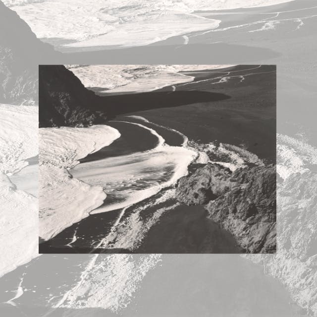 대조적인 질감으로 둘러싸인 바위 지형을 따라 구불구불한 강이 흐르는 흑백 풍경.