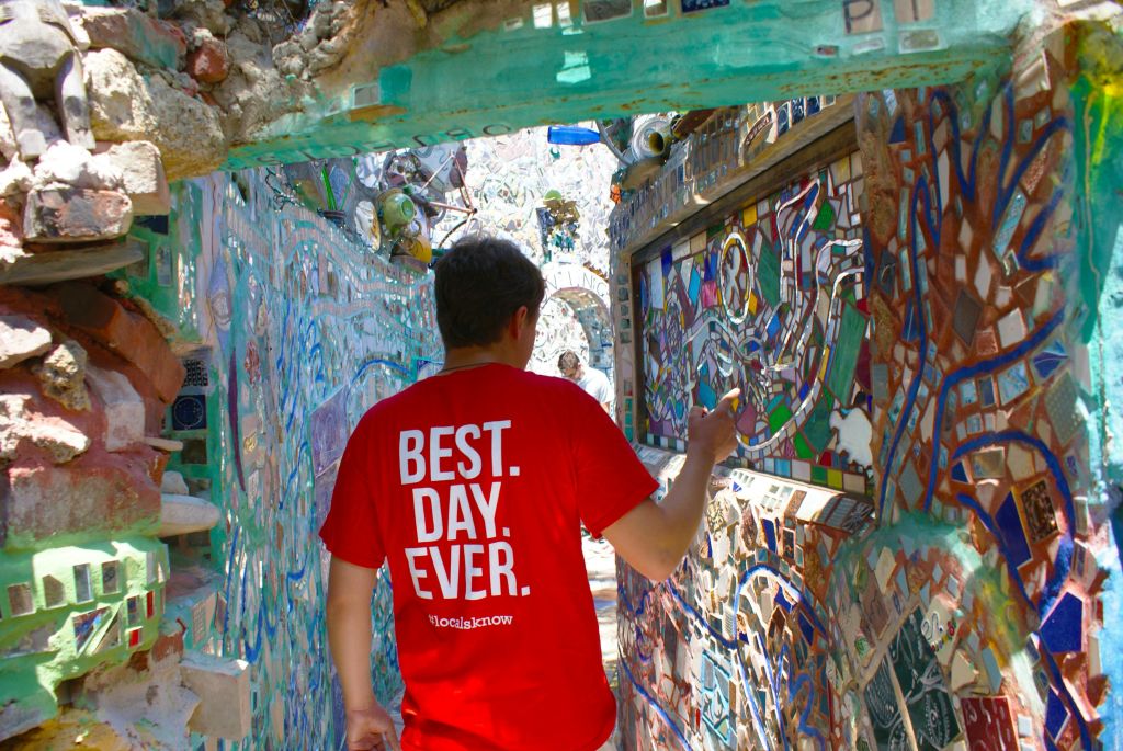 "최고" 의 빨간색 셔츠를 입은 사람. 날. 이제까지. "좁고 모자이크 타일로 장식된 복도를 탐색합니다.