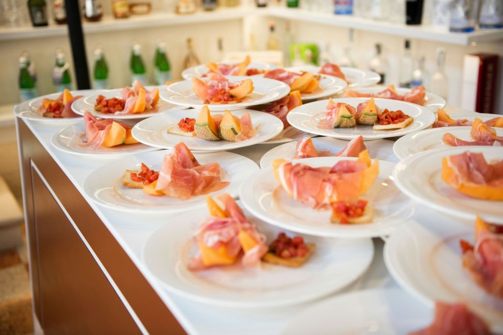 프로슈토로 포장된 멜론과 브루스케타가 깔끔하게 테이블 위에 놓여 있습니다.