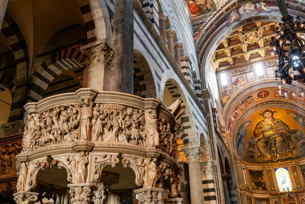 화려한 아치, 기둥, 장식된 천장을 배경으로 네 사람이 대성당에서 미소를 짓고 있습니다.