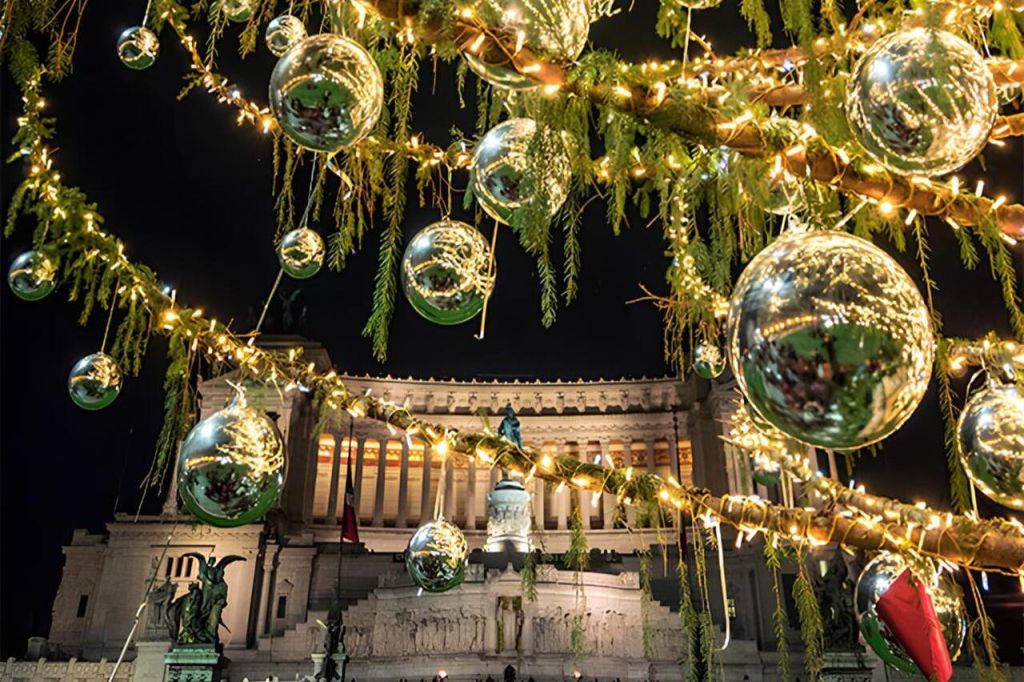 밤에 웅장한 건물 앞에서 황금빛 조명과 반사 장식으로 크리스마스 장식을 조명합니다.