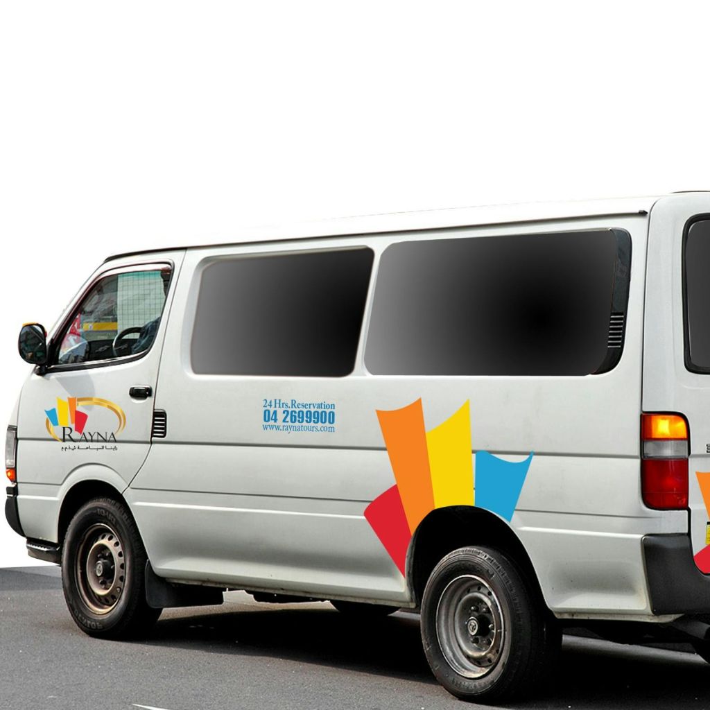 화려한 데칼이 달린 흰색 밴이 거리에 주차되어 있습니다. 텍스트와 로고는 측면에 연락처 정보와 브랜딩을 표시합니다.