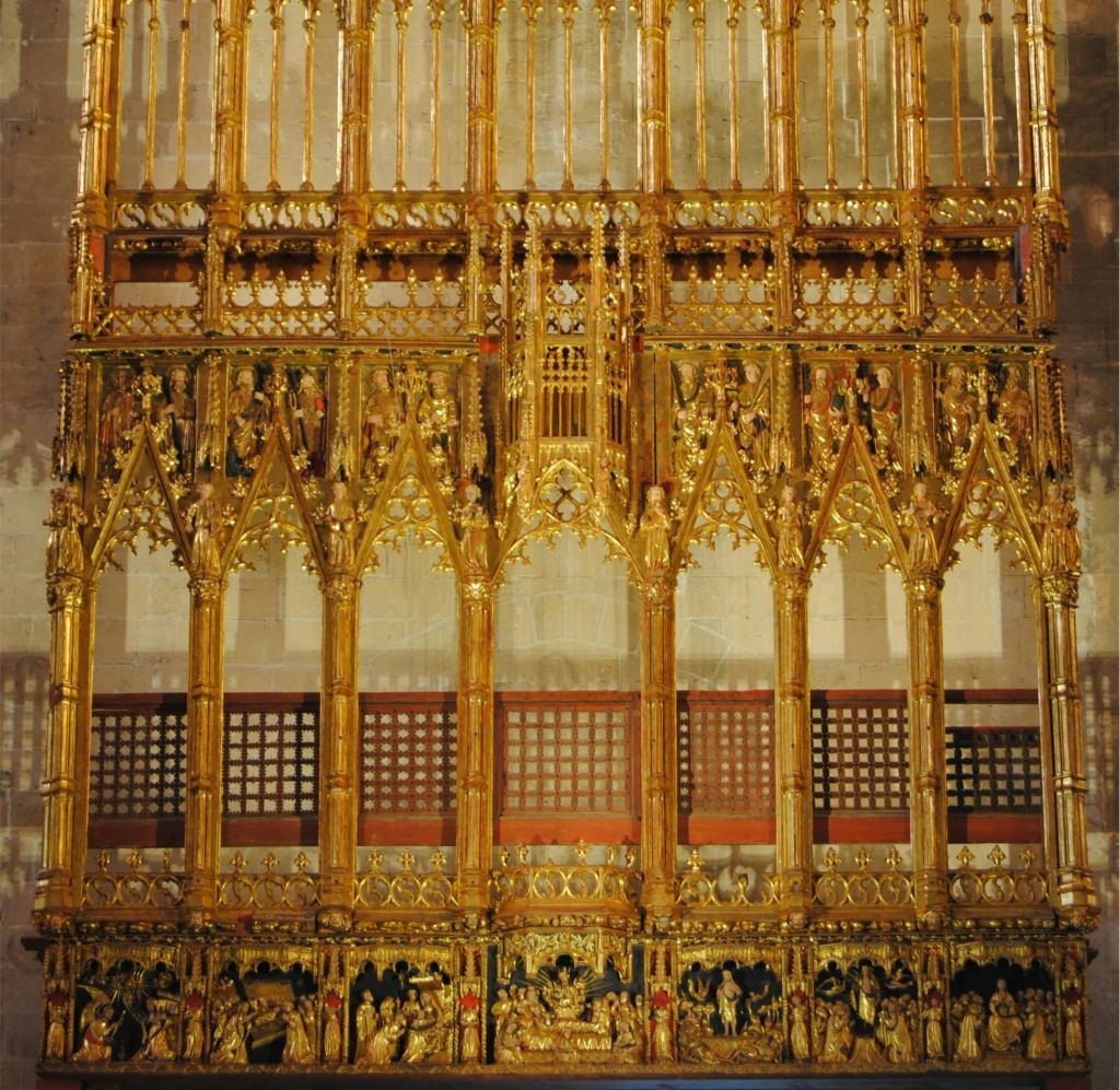 정교한 고딕 디자인의 화려한 황금 제단화로, 아치, 종교적 인물, 세부 조각이 특징입니다.