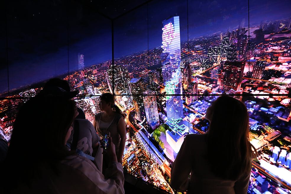 밝게 빛나는 고층빌딩과 북적이는 거리를 배경으로 활기찬 야간 도시 풍경이 펼쳐집니다.