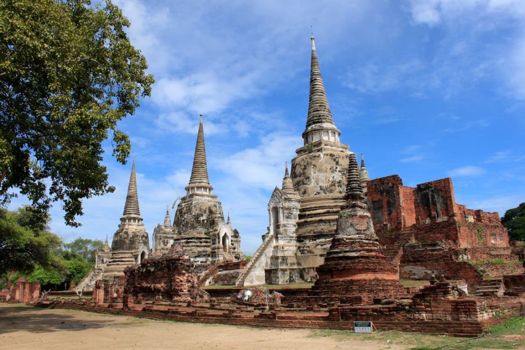 역사 유적지의 푸른 하늘 아래 있는 고대 스투파와 벽돌 유적.