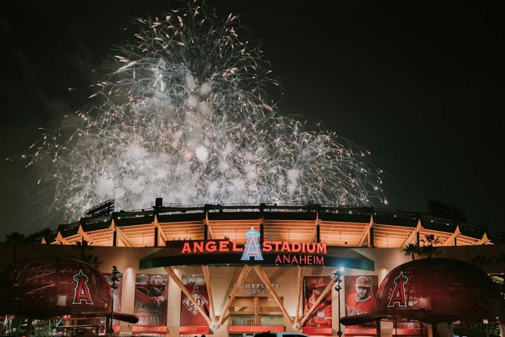 정문 위 하늘을 밝히는 불꽃놀이가 있는 애너하임의 엔젤 스타디움 야경.