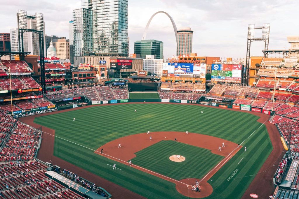 게이트웨이 아치를 배경으로 도시 경관이 펼쳐지는 경기장에서 야구 경기가 진행되고 있습니다.