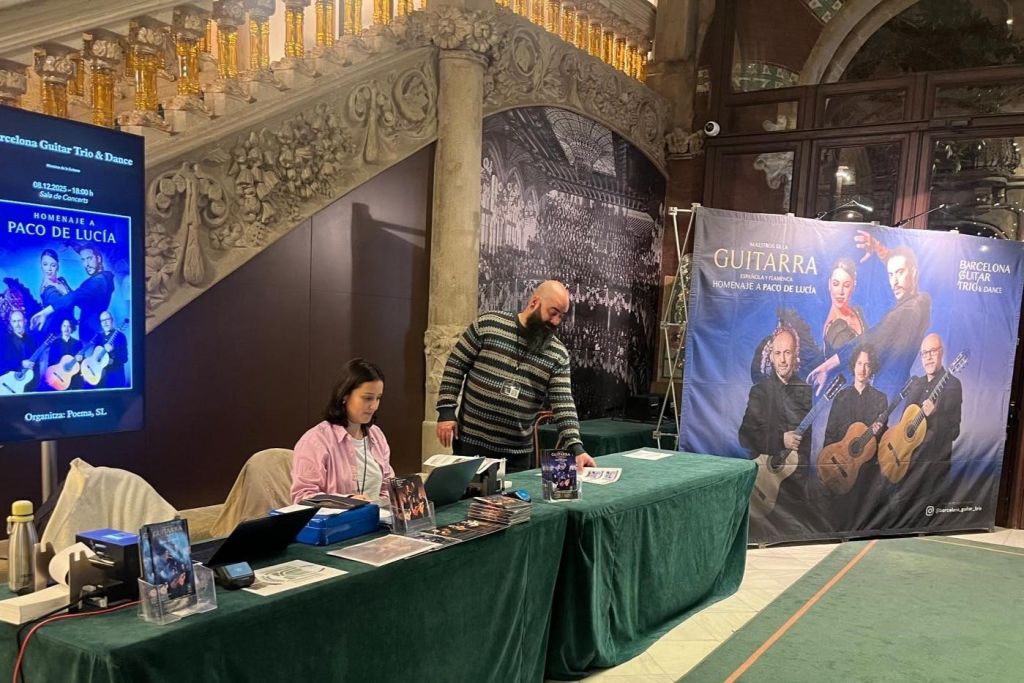 실내 장식 공간의 테이블에 두 사람이 앉아 홍보 자료와 행사를 위한 포스터를 전시하고 있습니다.