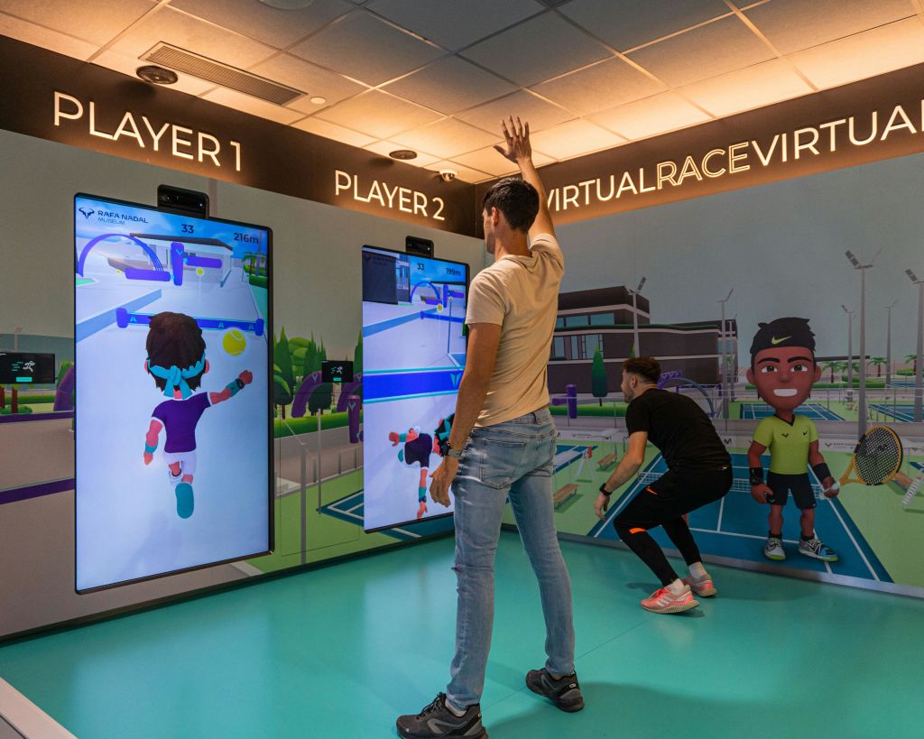 장애물 코스에서 라파 나달과 경쟁하는 대화형 게임을 하는 두 사람.