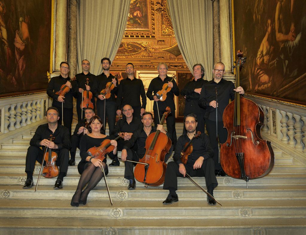 화려한 계단을 배경으로 세밀한 금장 장식이 돋보이는 현악기를 들고 있는 뮤지션들이 포즈를 취하고 있습니다.