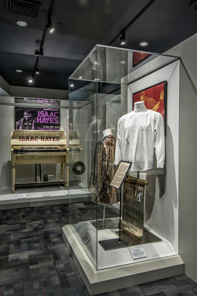 아이작 헤이즈의 기념품, 의복, 그의 이름이 새겨진 피아노, 액자에 담긴 예술품이 전시되어 있습니다.