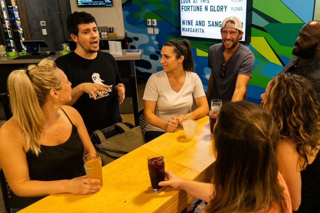 Tour guide talking to guests while having drinks