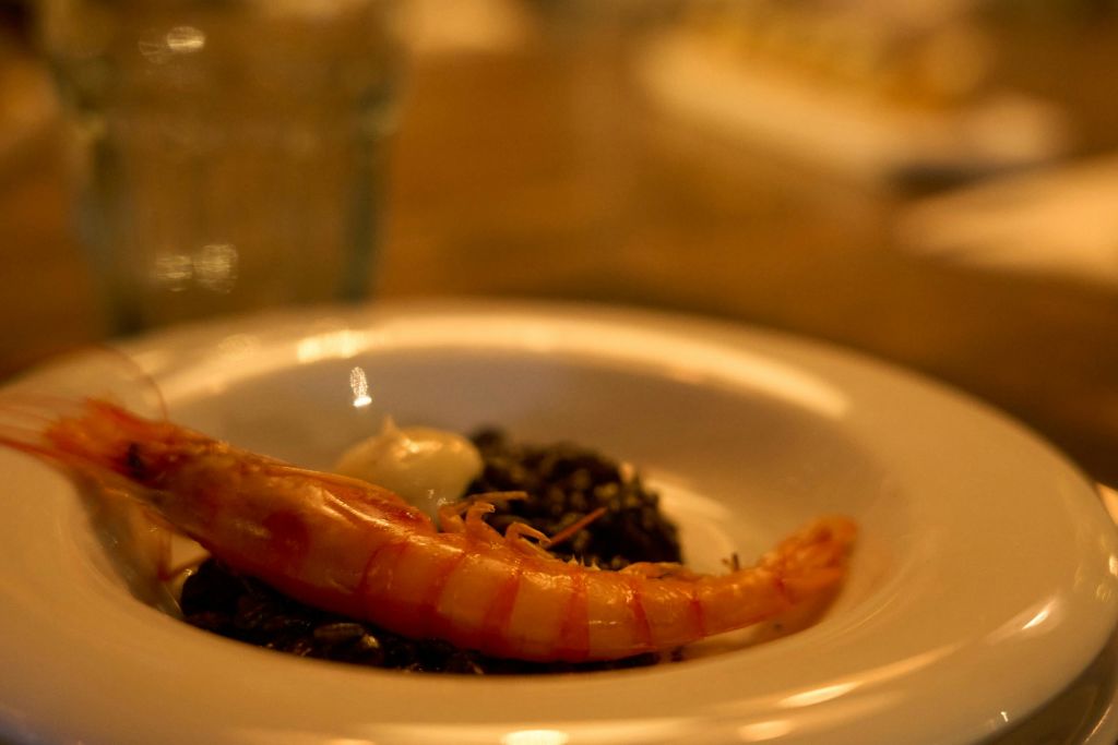 바르셀로나 엘 보른 (El Born) 에서 고급 식사를 즐길 수 있는 정교한 새우 요리가 흑미와 함께 제공됩니다.