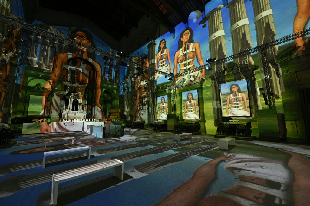 멀티미디어 아트 설치 작품은 벽과 바닥에 여성의 이미지와 고전 건축물을 투영한 것입니다.