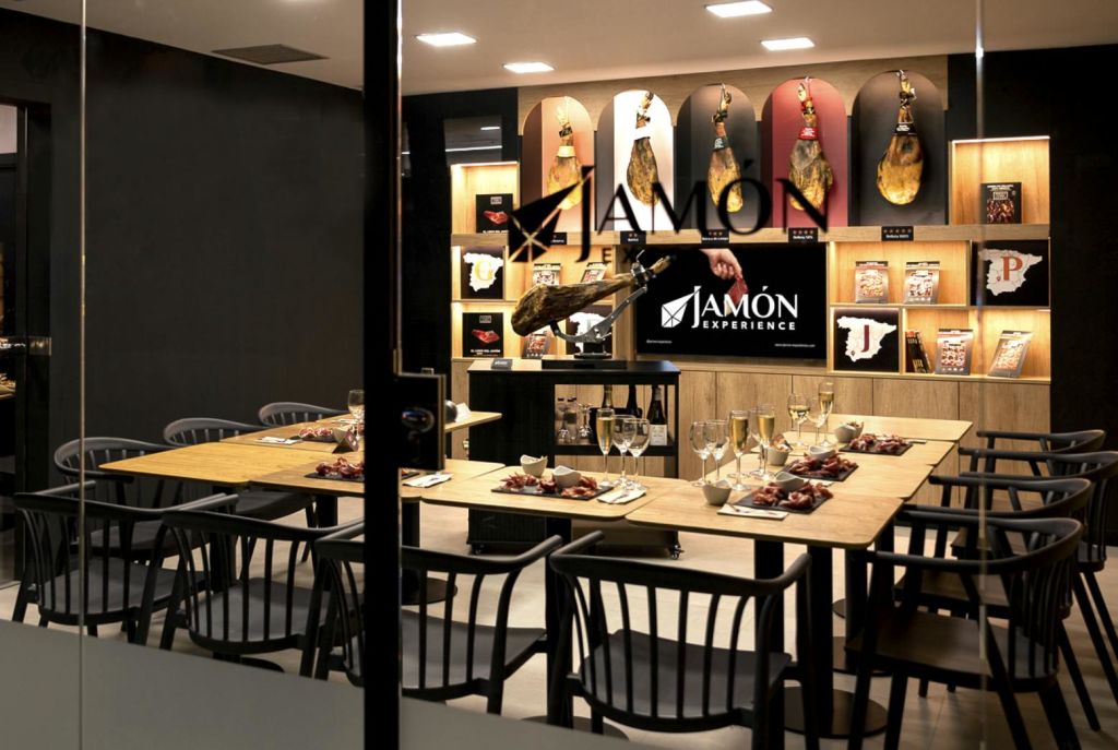 식사를 위한 테이블이 마련된 식사 공간, 경화육이 진열된 카운터, '자몬 체험' 표지판이 있습니다.