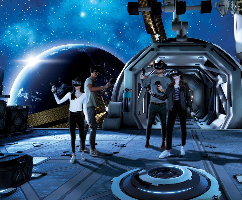 VR 헤드셋을 착용하고 컨트롤러를 들고 외부에 지구가 보이는 우주 정거장에 서 있는 4명의 사람들.