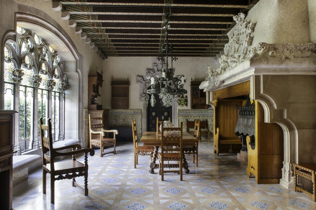 화려한 나무 의자, 긴 테이블, 샹들리에, 벽난로, 디테일한 조각이 있는 앤티크 다이닝 룸.