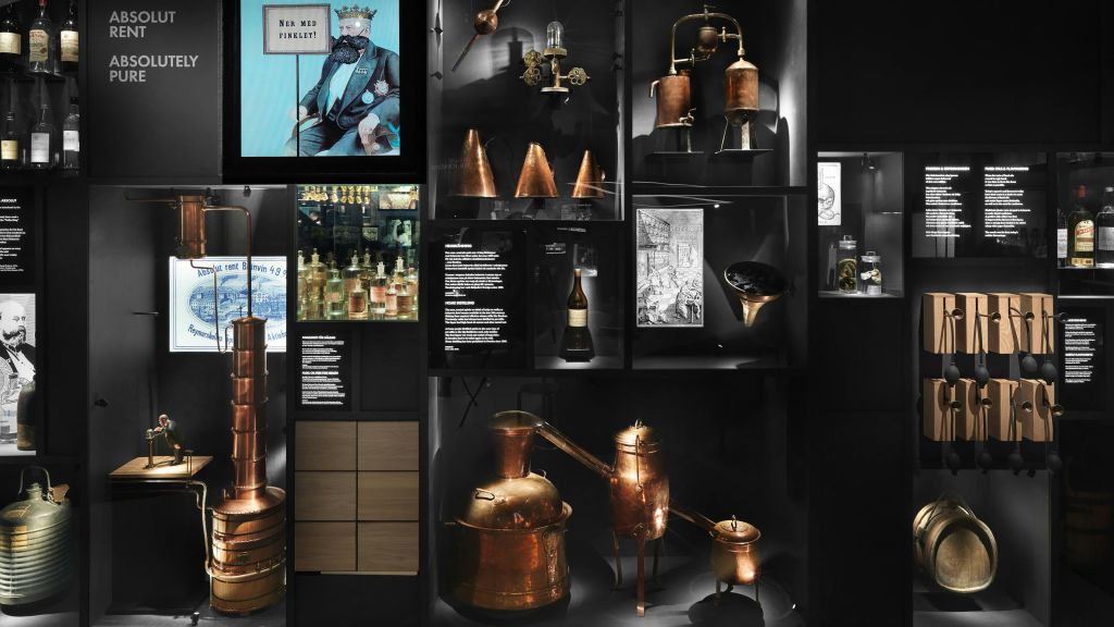 빈티지 증류 장비, 구리 장치, 역사적인 사진 및 다양한 유물을 박물관 환경에서 전시합니다.