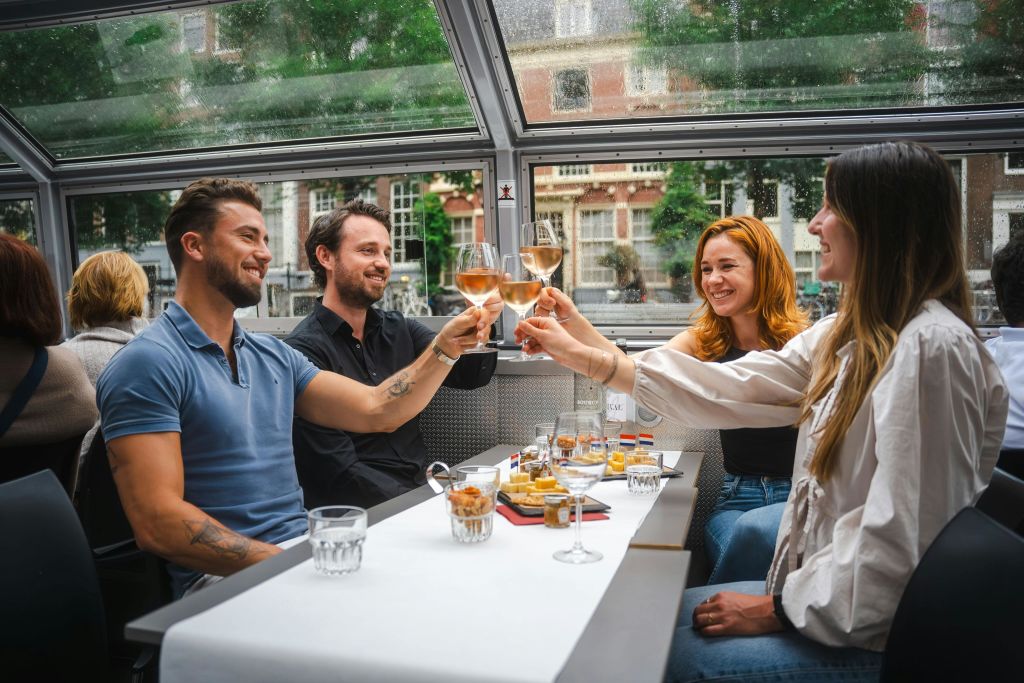 한 무리의 친구들이 치즈와 와인을 곁들인 보트 투어를 즐기고 있습니다.