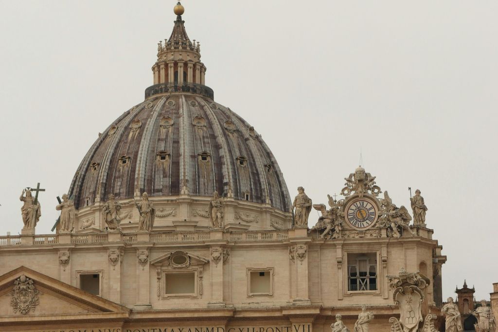 정교한 디테일과 조각상, 시계가 있는 커다란 돔형 구조는 중요한 건축 건물을 암시합니다.
