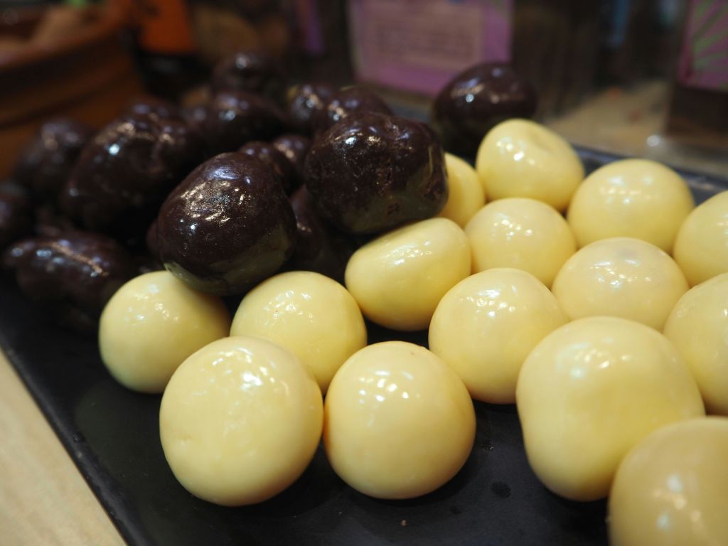 흰색과 다크 초콜릿으로 코팅된 둥근 사탕을 두 개의 별도 클러스터에 배치한 플레이트의 클로즈업.