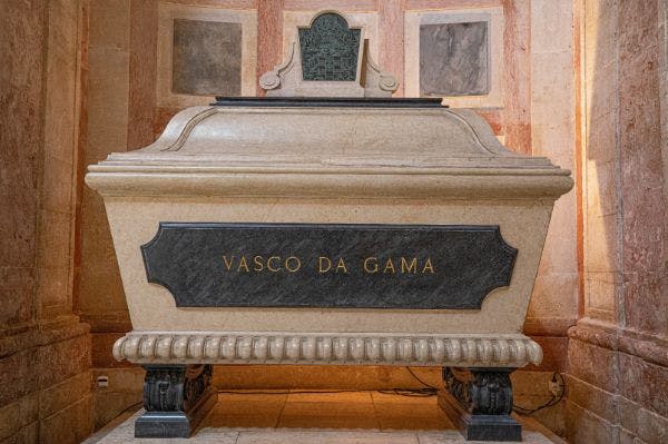 "바스코 다 가마 (Vasco Da Gama)" 가 눈에 띄게 새겨진 돌 무덤으로, 대리석으로 장식된 벽을 배경으로 화려한 디테일이 돋보입니다.