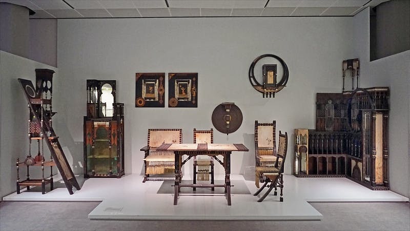 테이블, 의자, 벤치 등 앤티크 원목 식탁세트가 있는 객실입니다. 액자 두 개와 원형 벽 장식이 보입니다.