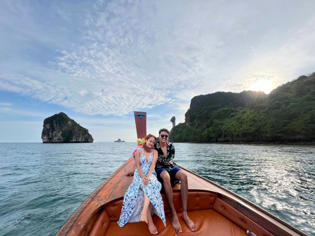 아름다운 절벽과 흐린 하늘을 배경으로 나무로 만든 보트 활에 두 사람이 앉아 있습니다.