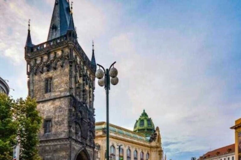 부분적으로 흐린 하늘 아래 녹색 돔이 있는 화려한 건물 옆에 뾰족한 첨탑이 있는 역사적인 석탑.