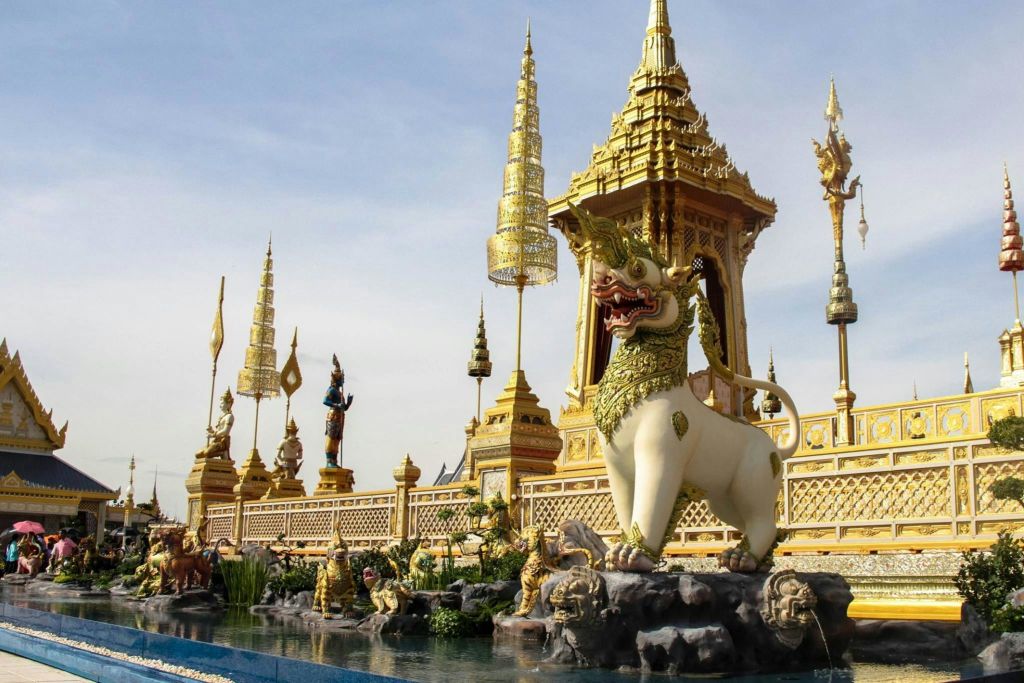 황금 첨탑, 정교한 조각상, 커다란 신화적 조형물로 장식된 화려한 태국 사원입니다.