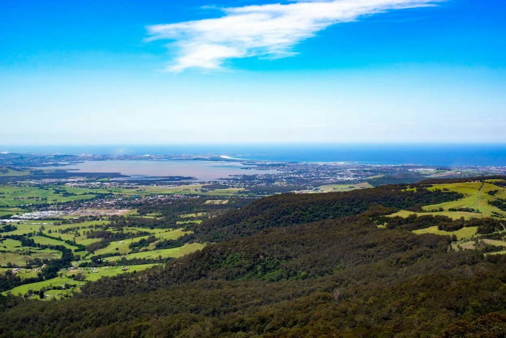 숲과 들판이 있는 울창한 계곡, 먼 마을, 구름이 있는 푸른 하늘 아래 펼쳐진 바다의 파노라마 전망.