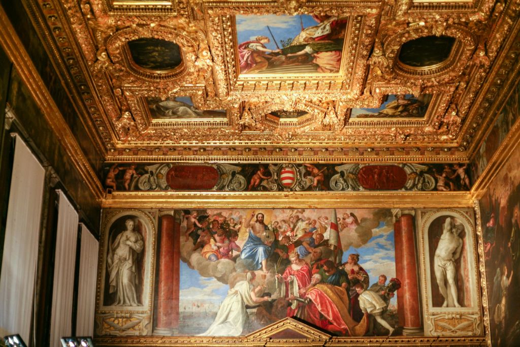 화려한 천장에는 복잡한 황금색 디자인과 다양한 종교적 장면을 묘사한 화려한 르네상스 프레스코화가 있습니다.