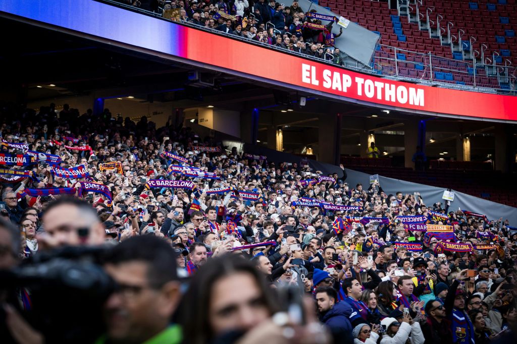 "EL SA" 를 표시하는 대형 스크린 아래에 "FC 바르셀로나" 라는 글자가 적힌 스카프를 들고 있는 많은 스포츠 팬들이 경기장에 몰려 있습니다.