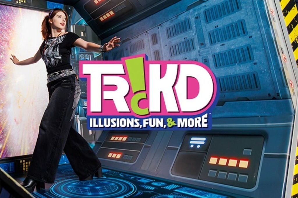한 여성이 "Trick 'd: Illusions, Fun, and More" 라는 텍스트 옆에 선명한 조명이 있는 미래 지향적 환경에서 극적인 포즈를 취하고 있습니다.