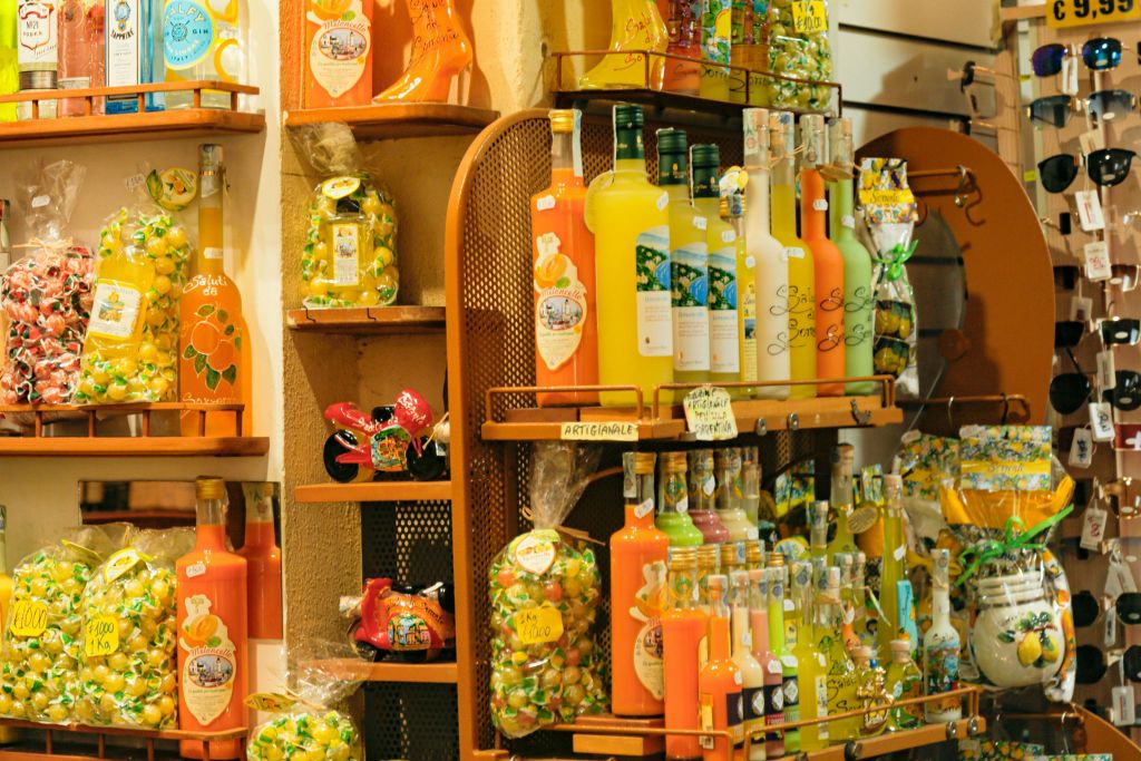 다양한 주류의 다채로운 병, 사탕 봉지 및 기타 포장된 상품이 매장에 가득한 선반.