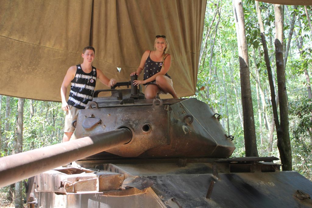 숲 속 캐노피 아래에서 나무를 배경으로 두 사람이 오래된 수조에서 포즈를 취하고 있습니다.