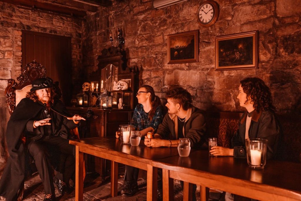 Meggets Celler에서 술과 이야기를 즐기는 방문객