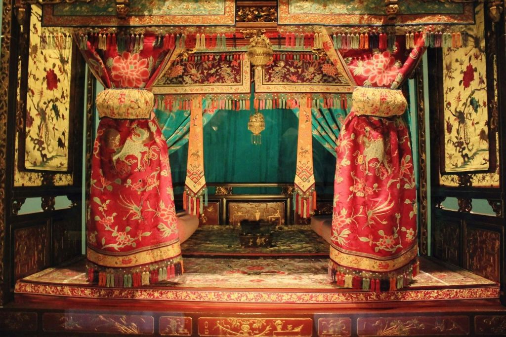 쿠션이 있는 좌석 공간과 장식용 금색 요소가 있는 정교한 빨간색과 금색 커프스가 있는 화려하고 다채로운 객실.