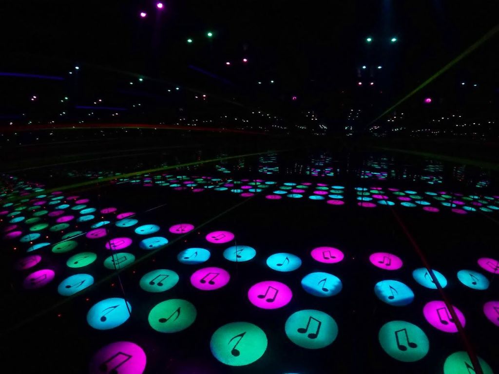 파란색, 분홍색 및 녹색으로 빛나는 악보 아이콘이 거울에 반사되어 끝없는 패턴의 환상을 만듭니다.