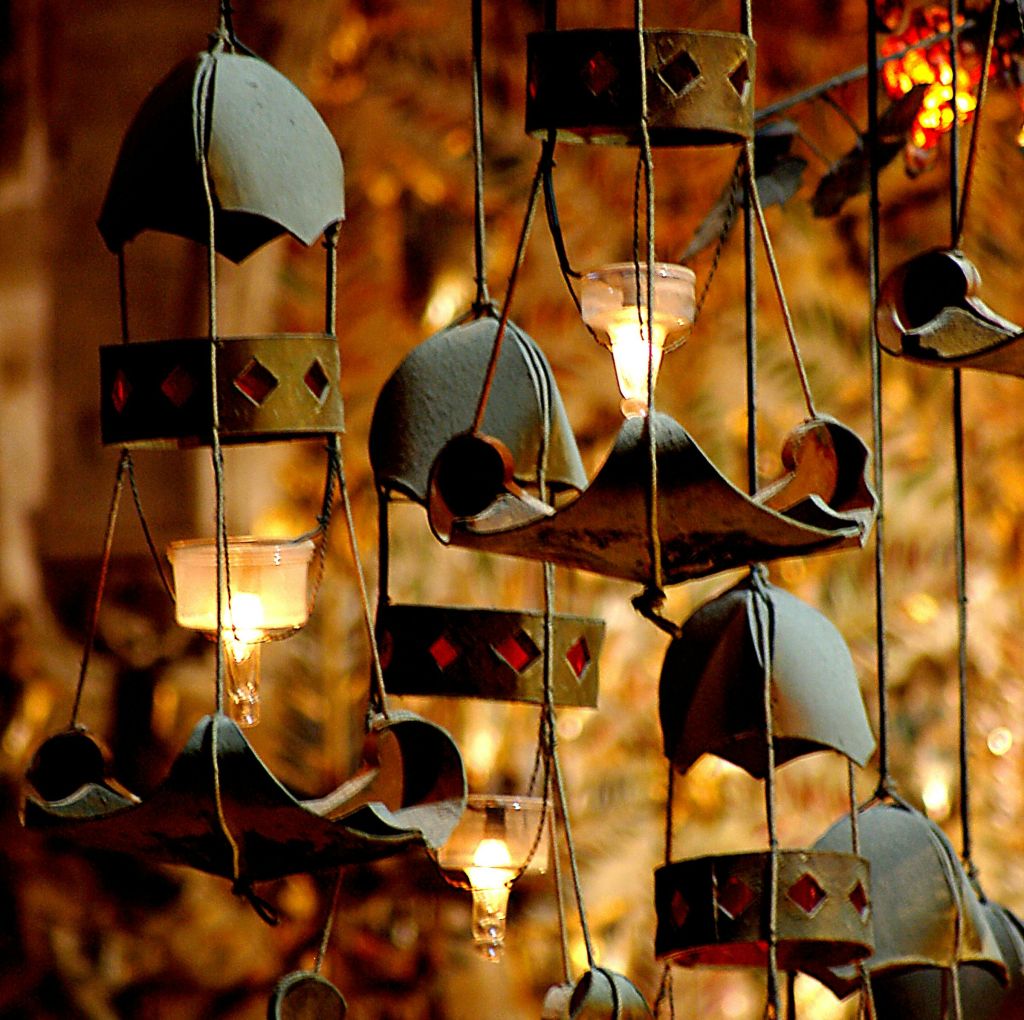 종 모양, 작은 조명, 붉은 다이아몬드 패턴이 흐릿하고 따뜻한 톤의 배경에 매달려 있습니다.