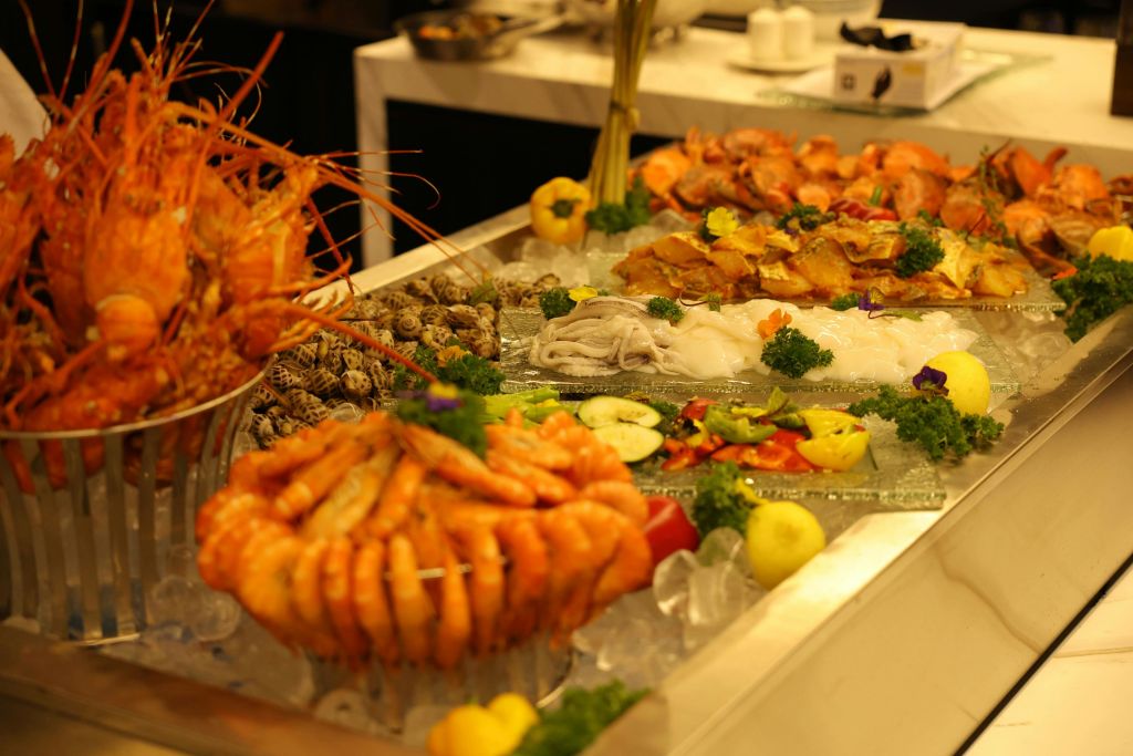 해산물 뷔페에는 새우, 게, 조개류, 채소 썰기 등 다양한 아이템이 얼음 위에 준비되어 있습니다.