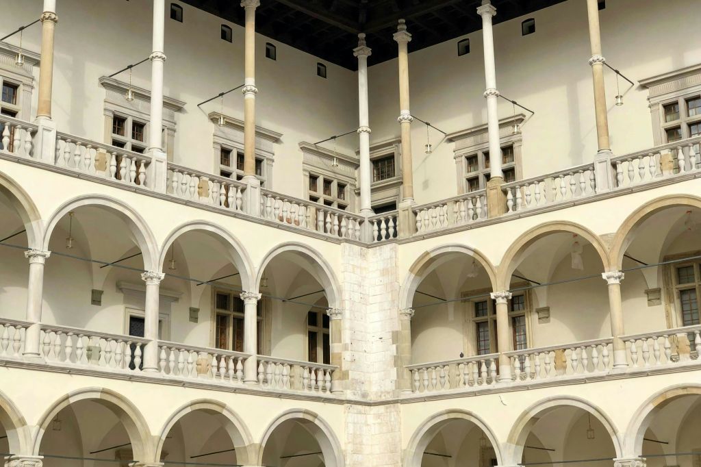 여러 개의 창문이 있는 아치, 기둥, 발코니가 있는 역사적인 건물의 코너 전망.