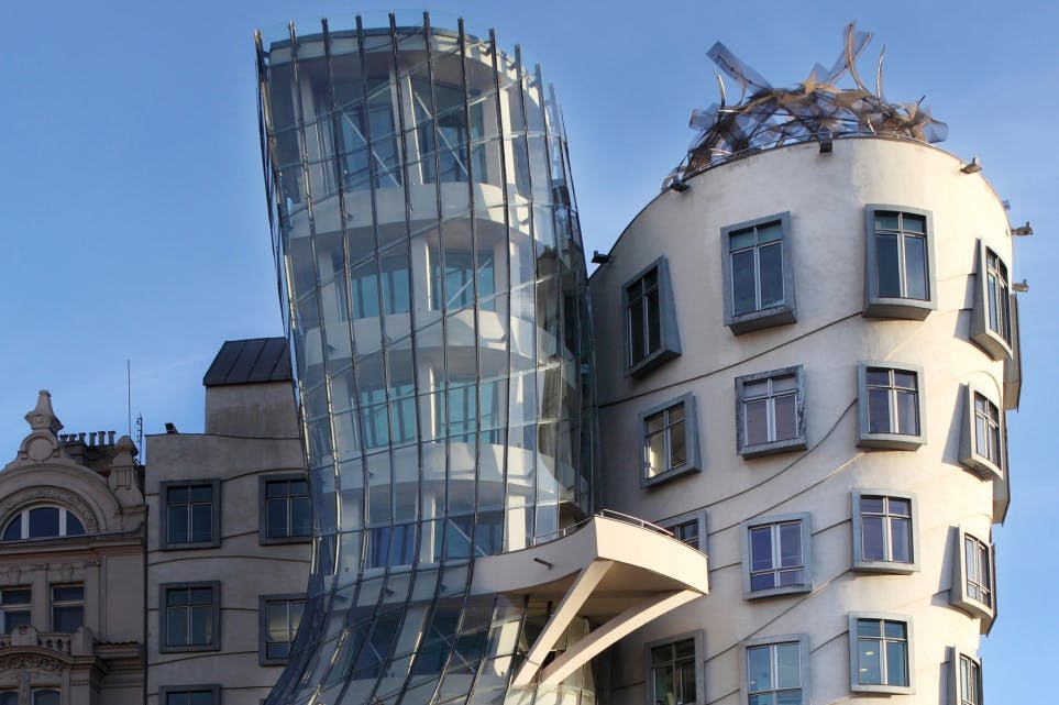 서로 연결된 두 개의 현대적이고 독특한 모양의 건물은 수많은 창문과 맑은 하늘 아래 구부러진 유리 외관을 갖추고 있습니다.