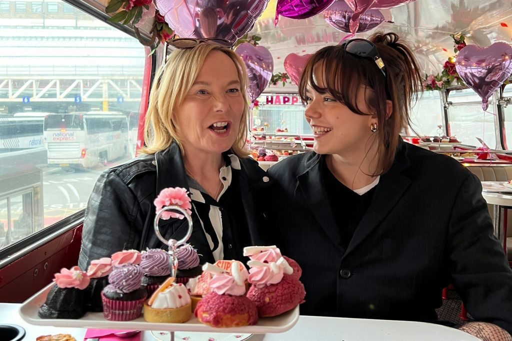 컵케이크와 하트 모양의 장식이 놓인 축제 분위기에서 두 사람이 서로 미소 짓고 있습니다.