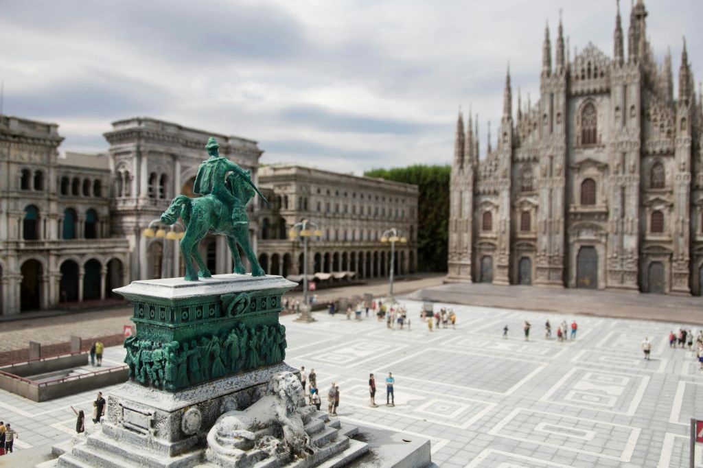 말과 기수의 동상, 섬세한 건축물, 대성당을 배경으로 한 도시 광장.