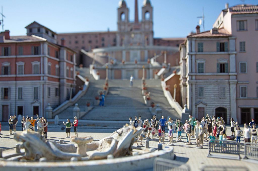 분수, 계단, 미니어처 피규어가 있는 도시 광장의 상세한 모델로, 공공장소에서 사람들을 나타냅니다.