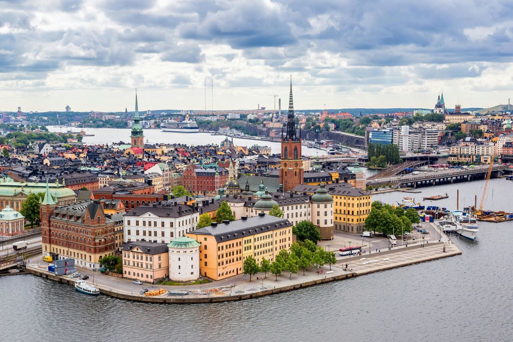 화려한 건물, 저명한 교회 타워, 워터프론트, 흐린 하늘이 있는 유럽 도시의 파노라마 전망.