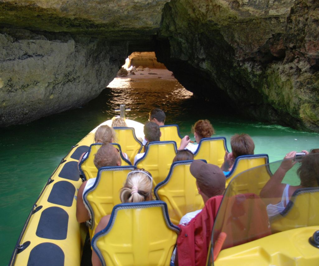 노란 뗏목을 탄 사람들이 물이 흐르는 어두운 동굴로 들어갑니다.