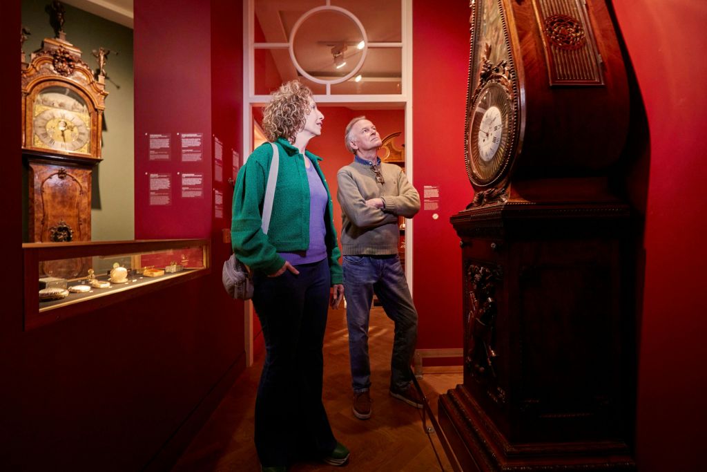 시계 옆에 서 있는 남녀